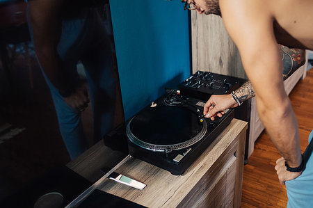 simsearch:614-07146137,k - Mid adult man playing vinyl record on turntable, cropped Photographie de stock - Premium Libres de Droits, Code: 614-09258491