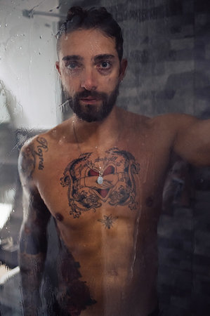 portrait tattoos for men - Mid adult man with tattooed chest in shower, portrait Foto de stock - Sin royalties Premium, Código: 614-09258503