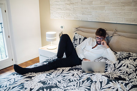 simsearch:614-09258474,k - Mid adult man reclining on bed using laptop Stockbilder - Premium RF Lizenzfrei, Bildnummer: 614-09258530