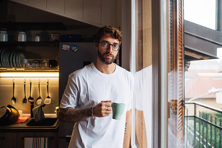 simsearch:614-09258506,k - Mid adult man with coffee by apartment window, portrait Photographie de stock - Premium Libres de Droits, Code: 614-09258532