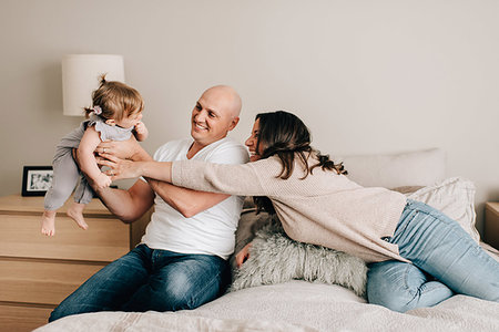 simsearch:649-07520605,k - Mother and father on bed lifting up baby daughter Photographie de stock - Premium Libres de Droits, Code: 614-09258616