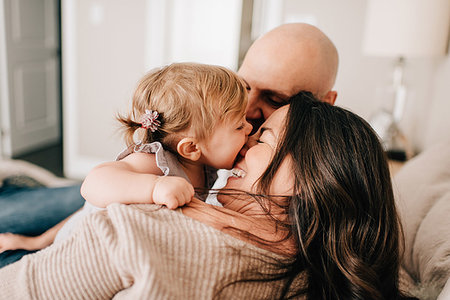 simsearch:614-09038702,k - Mother and father reclining on bed together with baby daughter, over the shoulder view Photographie de stock - Premium Libres de Droits, Code: 614-09258617