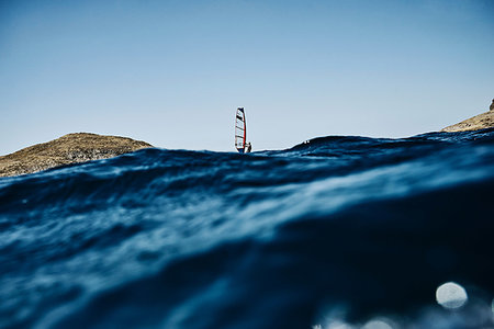 Young man windsurfing ocean waves, distant surface level view, Limnos, Khios, Greece Stock Photo - Premium Royalty-Free, Code: 614-09258718