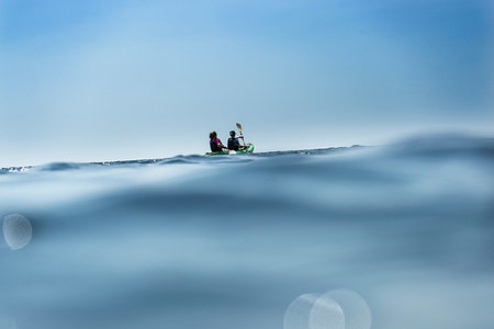 family far away - Teenage boy and mother sea kayaking, surface level distant view, Limnos, Khios, Greece Stock Photo - Premium Royalty-Free, Code: 614-09258724