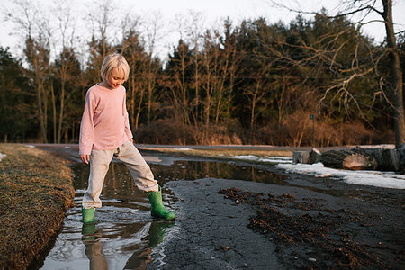 simsearch:614-09258754,k - Boy stepping ankle deep in rural meltwater puddle Photographie de stock - Premium Libres de Droits, Code: 614-09258770