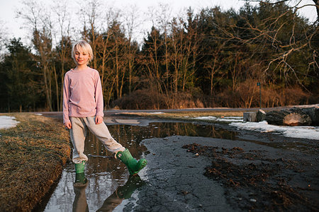 simsearch:614-09258754,k - Boy standing ankle deep in rural meltwater puddle, portrait Photographie de stock - Premium Libres de Droits, Code: 614-09258771