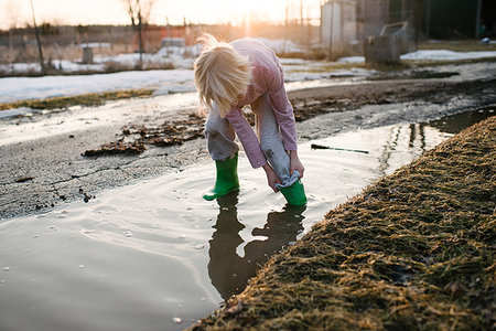 sich herumwälzen - Boy rolling trousers up in rural meltwater puddle Stockbilder - Premium RF Lizenzfrei, Bildnummer: 614-09258772