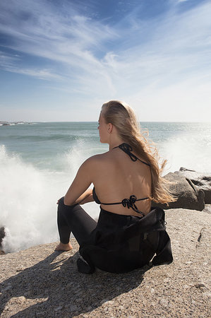 simsearch:614-09258792,k - Young female surfer with long blond hair sitting on beach rock, rear view, Cape Town, Western Cape, South Africa Stock Photo - Premium Royalty-Free, Code: 614-09258794