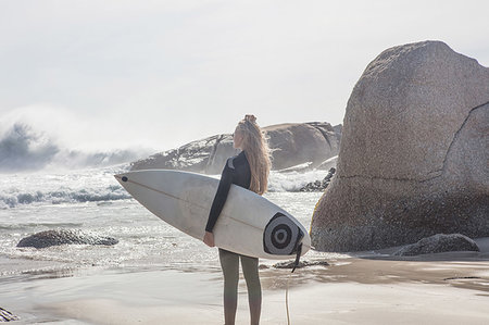 simsearch:614-09258792,k - Young female surfer carrying surfboard looking out at ocean waves from beach, Cape Town, Western Cape, South Africa Stock Photo - Premium Royalty-Free, Code: 614-09258802