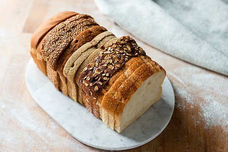 Sliced loaf made up of variety of white and wholemeal slices on cutting board, high angle view Stock Photo - Premium Royalty-Free, Code: 614-09258927