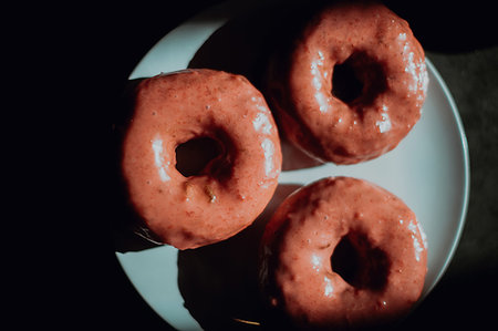 simsearch:649-08548172,k - Three iced doughnut holes on cafe table, low key overhead view Stock Photo - Premium Royalty-Free, Code: 614-09259060