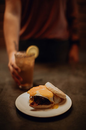 simsearch:614-08877000,k - Barista placing iced drink by fried egg muffin on cafe counter, cropped low key Photographie de stock - Premium Libres de Droits, Code: 614-09259081