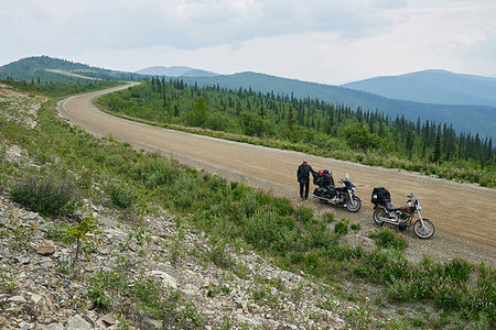 simsearch:862-06677518,k - Senior male motorcyclist on rural mountain roadside with motorbike, high angle portrait, Dawson Creek, Canada Photographie de stock - Premium Libres de Droits, Code: 614-09259164