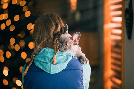 Girl carrying puppy indoors Stock Photo - Premium Royalty-Free, Code: 614-09253599