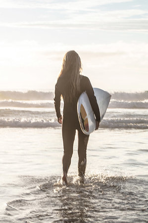 Female surfer carrying surfboard into sea, Cape Town, Western Cape, South Africa Stock Photo - Premium Royalty-Free, Code: 614-09253621