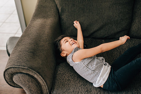 simsearch:614-09253640,k - Girl lying on armchair laughing Foto de stock - Sin royalties Premium, Código: 614-09253634