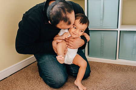 father baby boy diaper - Father kneeling on nursery floor playing with baby son Stock Photo - Premium Royalty-Free, Code: 614-09253649