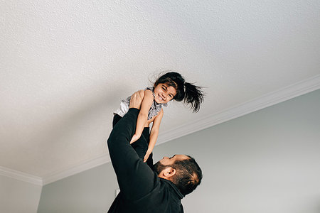 simsearch:614-09253659,k - Girl being held up to ceiling by father Stock Photo - Premium Royalty-Free, Code: 614-09253661