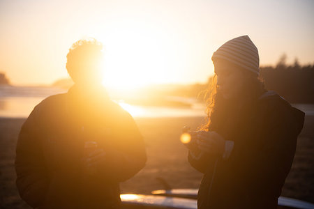 Two mid adult female friends on coast at sunset, Tofino, Vancouver Island, Canada Stock Photo - Premium Royalty-Free, Code: 614-09276360