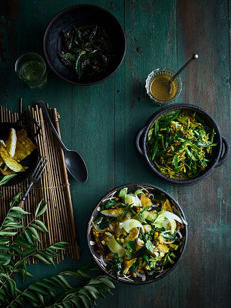 simsearch:649-06812137,k - Rustic low key still life with bowls of curry leaf fish salad and green bean thoran on table, overhead view Photographie de stock - Premium Libres de Droits, Code: 614-09276361