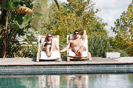 simsearch:614-09017276,k - Young couple relaxing on deckchair by swimming pool Photographie de stock - Premium Libres de Droits, Code: 614-09276539