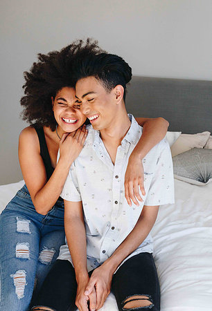 simsearch:614-09276991,k - Happy young woman with arms around boyfriend while sitting on bed Stock Photo - Premium Royalty-Free, Code: 614-09276587