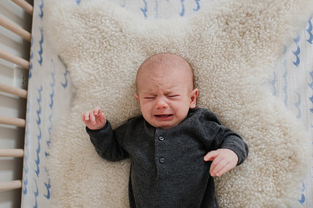 simsearch:614-06442839,k - Baby boy crying while lying on sheepskin rug in crib, overhead view Stockbilder - Premium RF Lizenzfrei, Bildnummer: 614-09276701