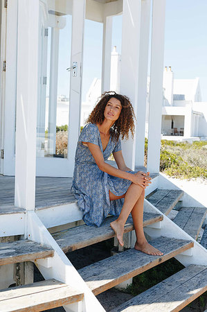 simsearch:614-09276458,k - Woman relaxing on steps in front of beach house Foto de stock - Royalty Free Premium, Número: 614-09276911