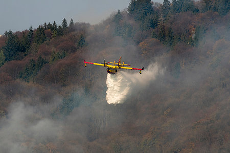 Canadair throwing water to extinguish fire on Sacro Monte, Varese, Italy Photographie de stock - Premium Libres de Droits, Code: 614-09277057