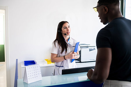 simsearch:614-09270097,k - Nurse speaking with patient at hospital reception Foto de stock - Royalty Free Premium, Número: 614-09270060