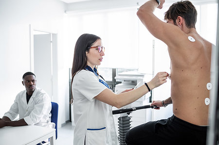 simsearch:614-09270097,k - Doctor watching nurse perform ECG test on patient in consultation room Foto de stock - Royalty Free Premium, Número: 614-09270105