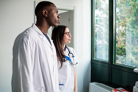 simsearch:614-09270097,k - Doctor and nurse looking out window in hospital Foto de stock - Royalty Free Premium, Número: 614-09270112