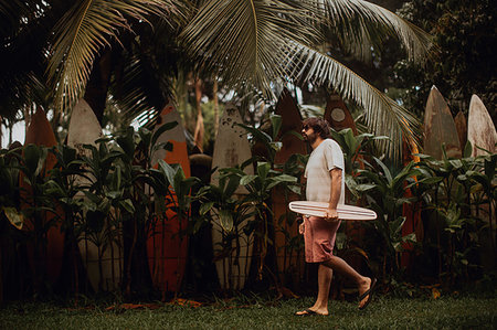 simsearch:6109-08929136,k - Mid adult male skateboarder carrying skateboard by old surfboard structure in park, Haiku, Hawaii, USA Stockbilder - Premium RF Lizenzfrei, Bildnummer: 614-09270191