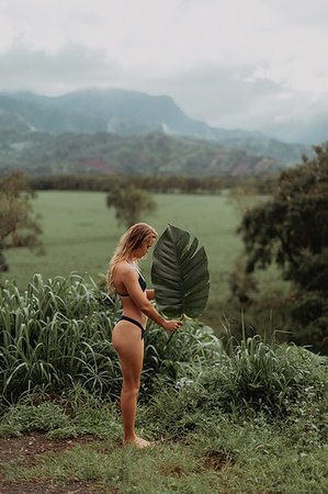 seduction in forest - Woman in bikini holding large leaf, Princeville, Hawaii, US Stock Photo - Premium Royalty-Free, Code: 614-09270232