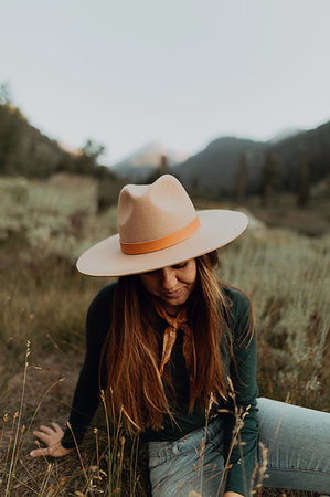 simsearch:649-09251794,k - Young woman in stetson sitting and looking down in rural valley, Mineral King, California, USA Photographie de stock - Premium Libres de Droits, Code: 614-09270423