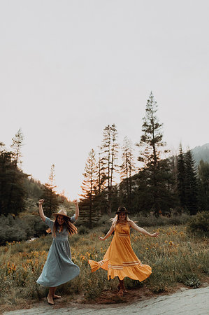 Two women in maxi dresses dancing in rural valley, Mineral King, California, USA Fotografie stock - Premium Royalty-Free, Codice: 614-09270497