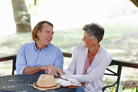 Couple enjoying conversation under shade in garden Stock Photo - Premium Royalty-Free, Code: 614-09270634