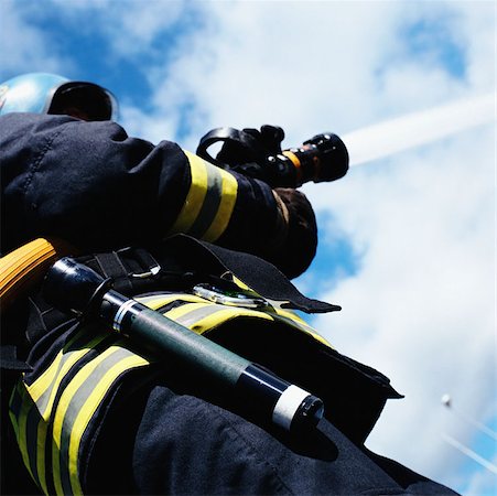 fire hose - Fireman operating hose Foto de stock - Sin royalties Premium, Código: 614-00389127