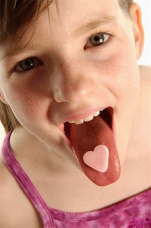 preteen girls tongue - Girl with heart shaped sweet on tongue Stock Photo - Premium Royalty-Free, Code: 614-00380897