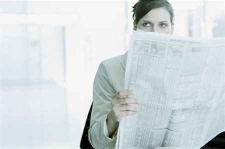 Businesswoman reading a paper in airport terminal Stock Photo - Premium Royalty-Free, Code: 614-00395669