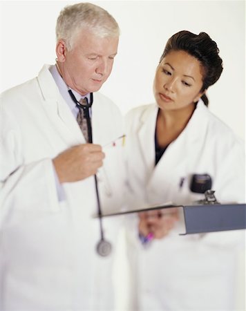 simsearch:614-08873482,k - Two doctors examining clipboard Fotografie stock - Premium Royalty-Free, Codice: 614-00597413