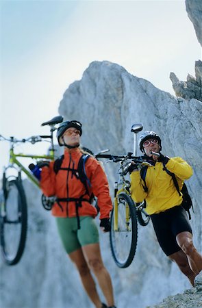 Man and woman carrying mountain bikes Stock Photo - Premium Royalty-Free, Code: 614-00599469