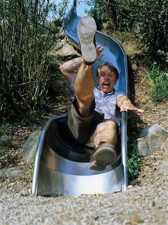 Excited man comes down slide. Stock Photo - Premium Royalty-Free, Code: 614-00599558