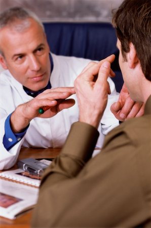 eye doctor speaking to patient - Man talking to a doctor Stock Photo - Premium Royalty-Free, Code: 614-00599667