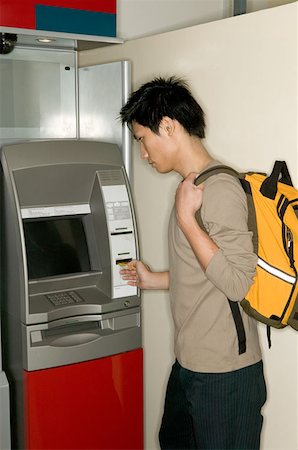 Man using a cash machine Stock Photo - Premium Royalty-Free, Code: 614-00600540