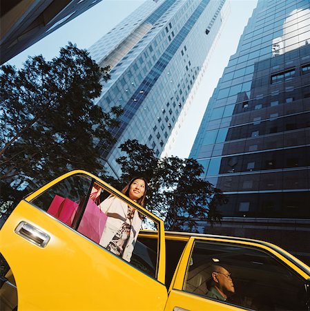 Woman leaving taxicab with shopping bags Foto de stock - Sin royalties Premium, Código: 614-00600557