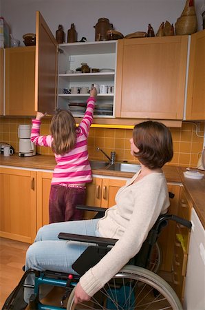 Disabled mother and daughter in kitchen Stock Photo - Premium Royalty-Free, Code: 614-00600910