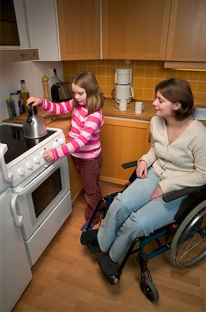 Disabled mother and daughter in kitchen Stock Photo - Premium Royalty-Free, Code: 614-00600911