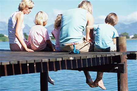 Family sitting on a jetty Stock Photo - Premium Royalty-Free, Code: 614-00601421