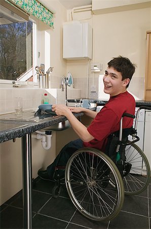 Disabled man washing up Stock Photo - Premium Royalty-Free, Code: 614-00601453